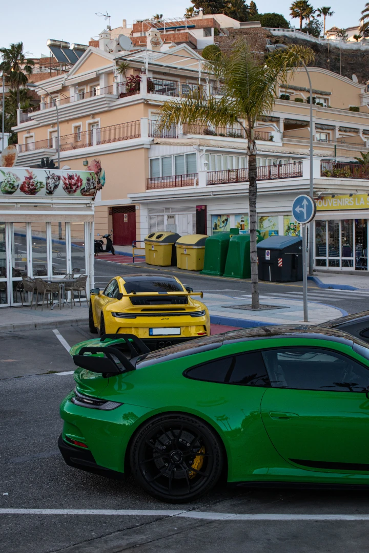 Two Porsche 992 GT3 cars parked on opposite sides of the road